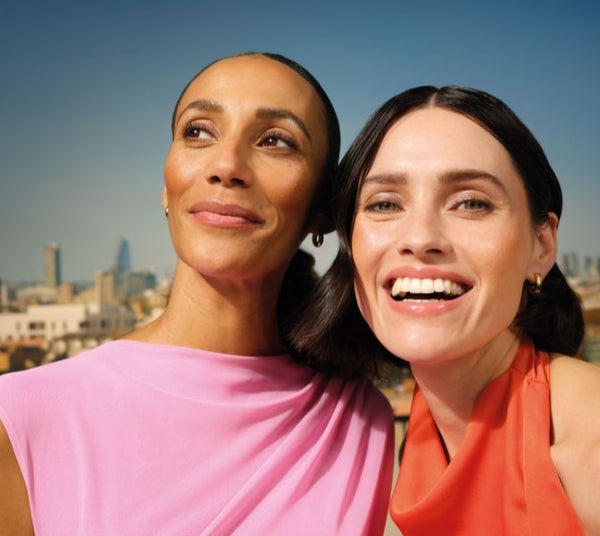 Two women smiling on a rooftop