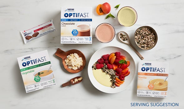 A table covered with Optifast Products including Shakes, Soups, Bars and Desserts.