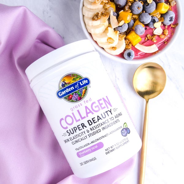 Garden of Life grass fed collagen, blueberry acai flavour next to a smoothie bowl decorated with fruit