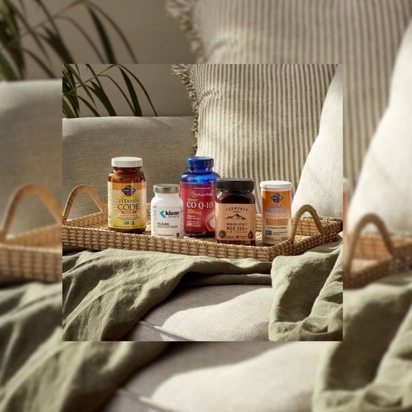Garden of Life vitamin code, Klean Athlete Multivitamin, Puritan's Pride CO Q-10, Egmont Honey and Garden of Life Ultimate Care on a tray in a soft plush background promoting Vitamins & Supplements category