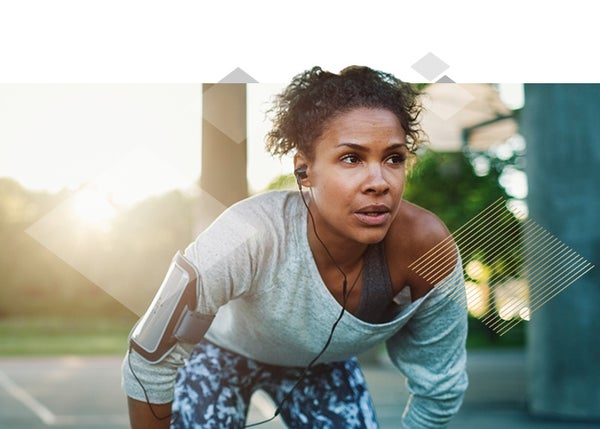 Women on a run crouching over with headphones in