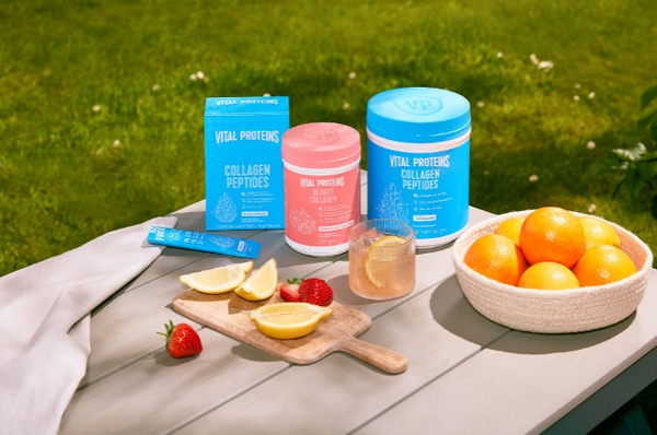 Vital proteins morning get up and glow tin standing next to the refreshing drink with an addition of the powder.