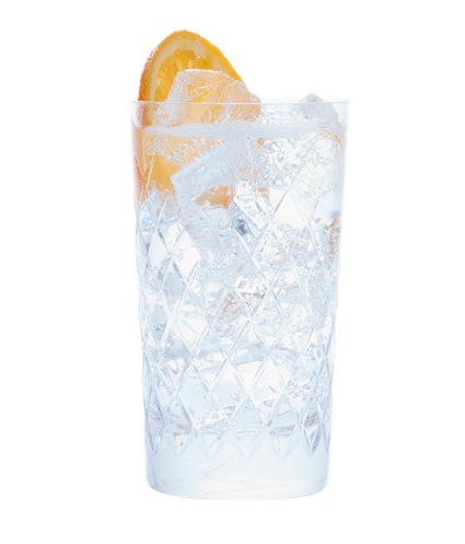 A glass containing ice, an orange slice and alcohol