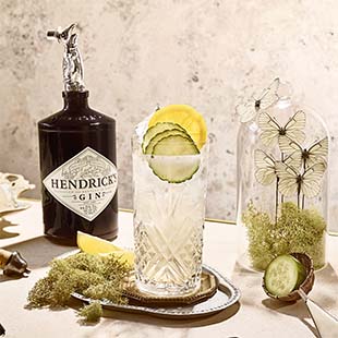 Hendricks Gin bottle with garnished drink on a tray