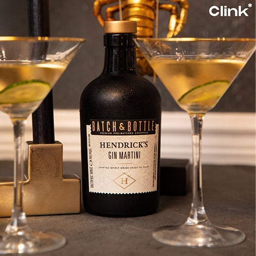 A bottle of Hendricks Gin Martini with two glasses containing the gin and a piece of cucumber