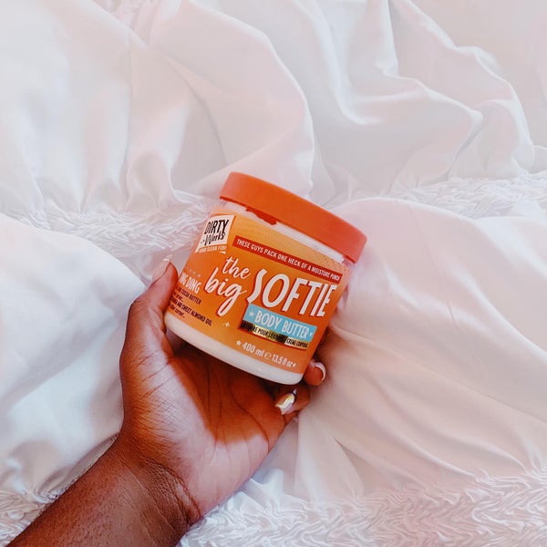 hand holding the big softie body butter on white sheets Visit Our Instagram