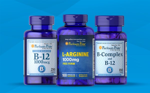 three packs of different supplements - B-12, L-Arginine and B-Complex - standing on a blue background.