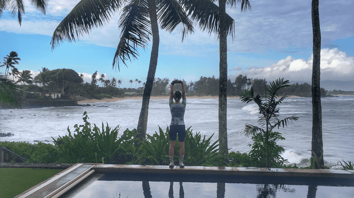 klean athlete stretching in blissful location with palm trees