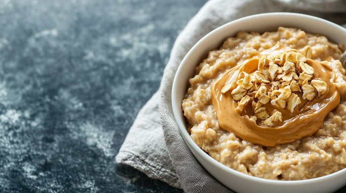 A bowl of oatmeal with protein powder and peanut butter.