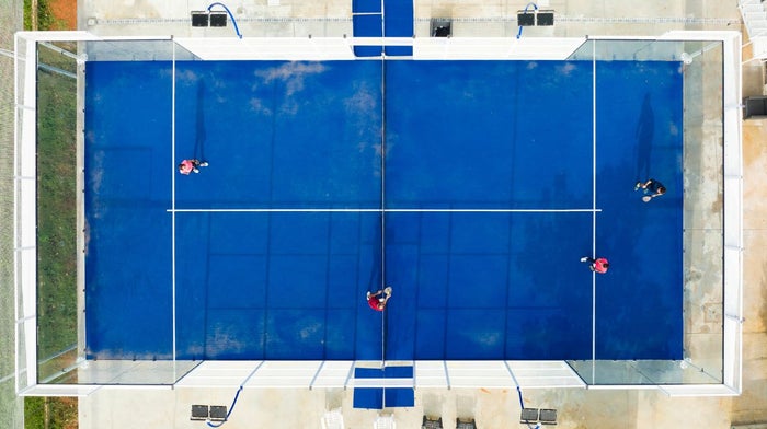 An aerial view of doubles playing on a padel court.