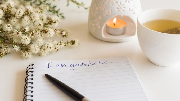 gratitude journal, candle and flowers