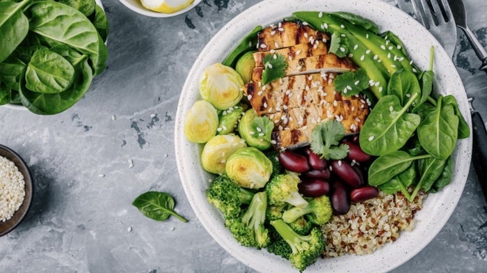 bowl of healthy food, such as chicken, vegetables and greens 