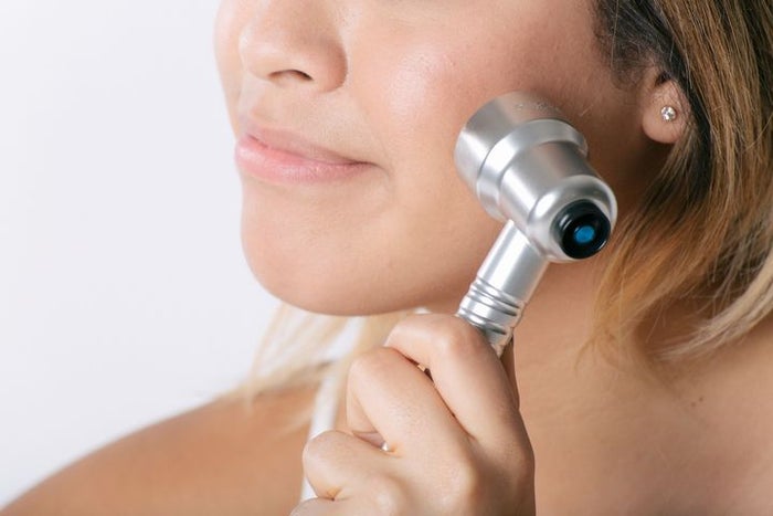 woman using a laser skin care device