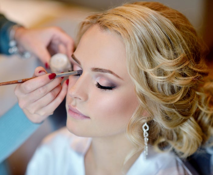 makeup artist applying bridal makeup