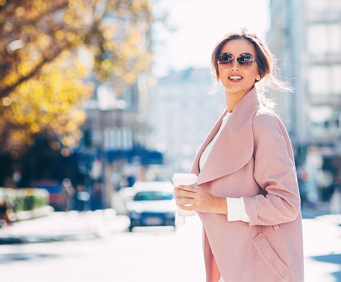 Woman in pink trench coat against fall background 2