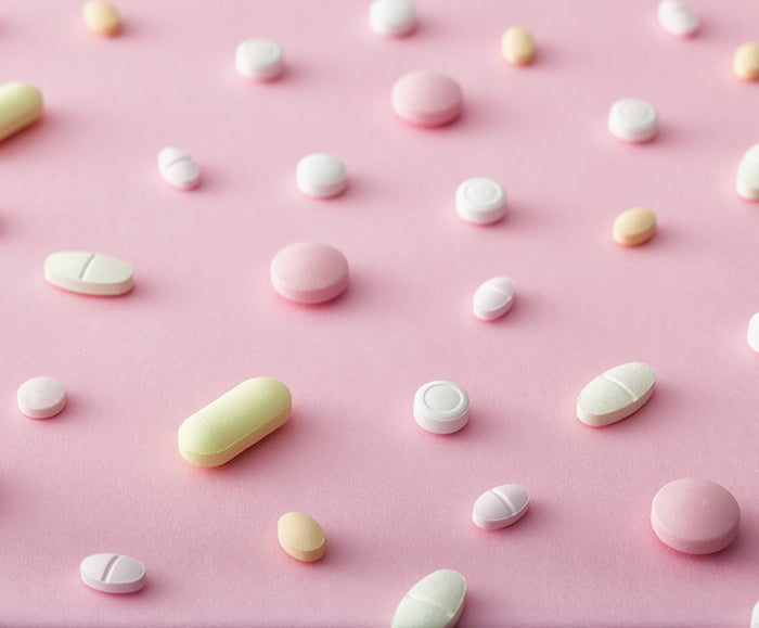 Scattered Pills on pink background I Dermstore Blog