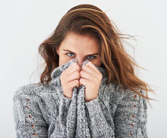 woman hiding face in sweater