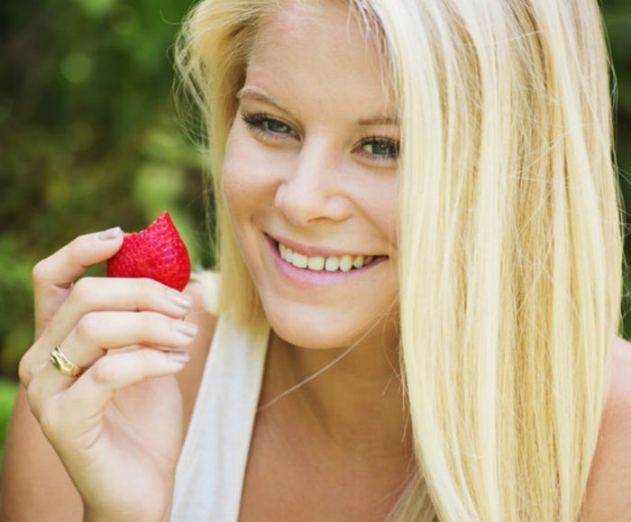 woman holding a strawberry