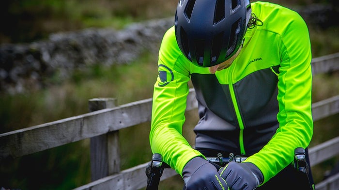 Cyclists sits on bike in yellow Endura waterproof