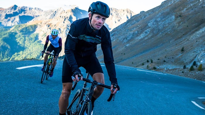 Cyclists descend steep hill in twilight