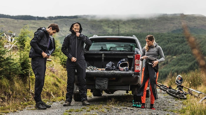 Team putting on Endura jackets in grassy hillside