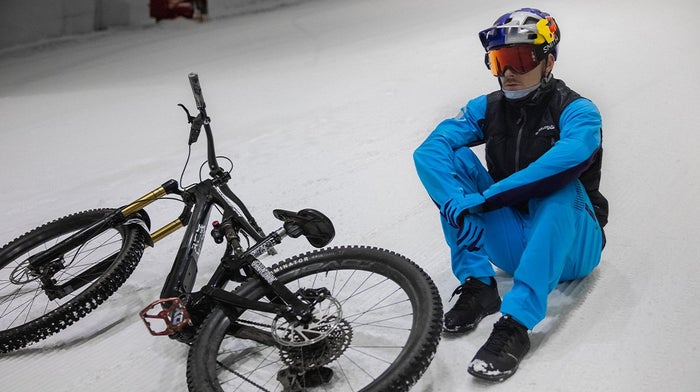 Man sits down in snow in Blue Endura clothes in the snow