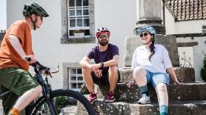   Group of three bike riders relaxing during a ride 