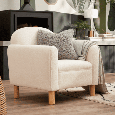 White fabric armchair with a grey fluffy pillow.