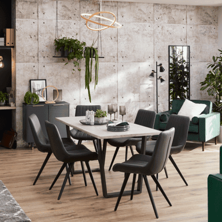 Grey chairs with black legs around a white table with decorative black legs.