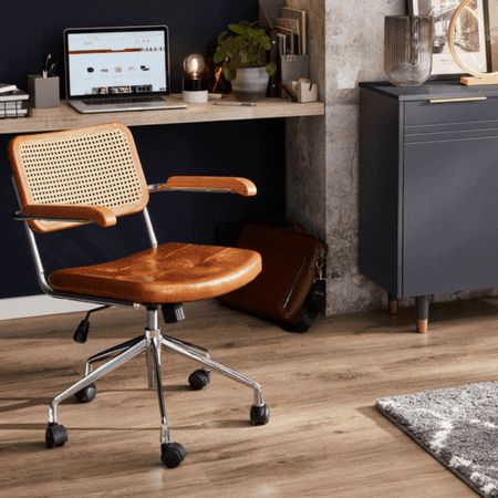 Brown desk chair with weaved back and a metal structure with wheels on the base.