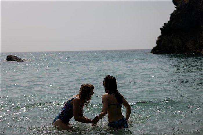 Couple in water celebrate sunshine in speedo swimwear