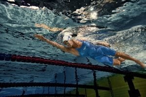 Competitive swimmer Emma McKeon performing front crawl in a swimming pool
