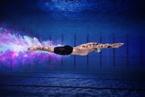 Adam Peaty swimming in a pool.