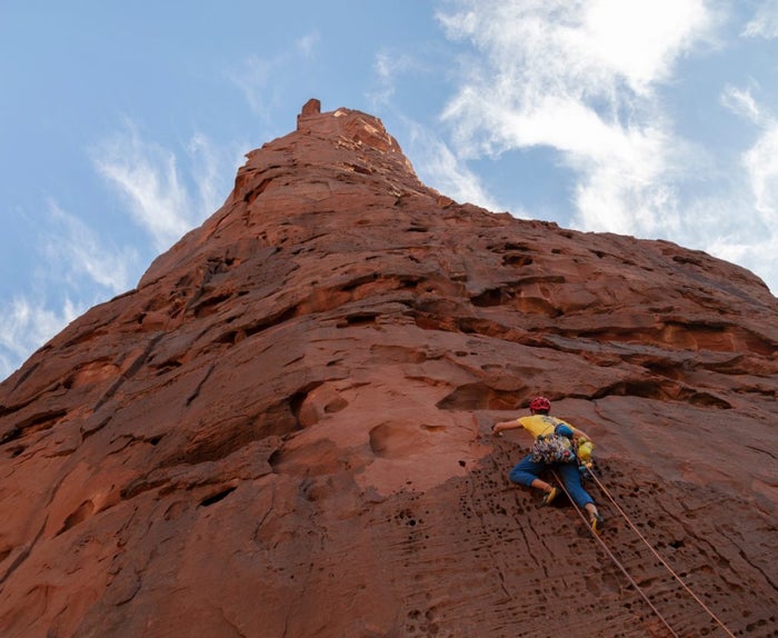 Arabian tower stretches high into the sky, with climber gripping onto the side