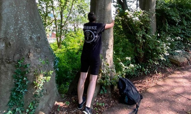 Man leans on dark tree