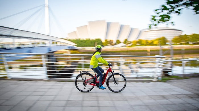 Woman cycles along quayside