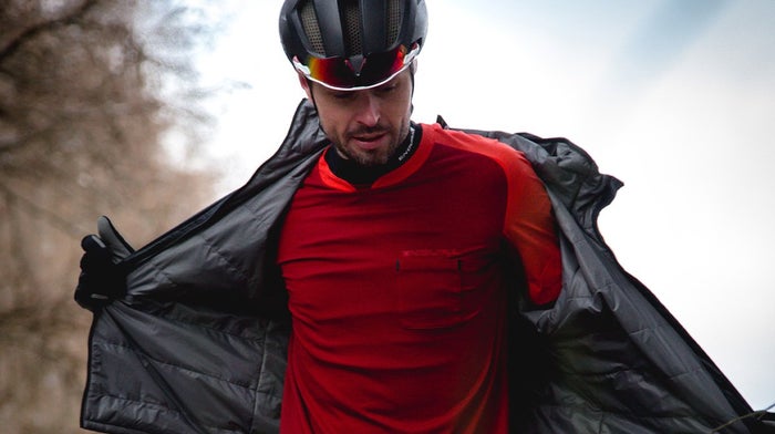 Man removes Endura black waterproof for red Endura t-shirt