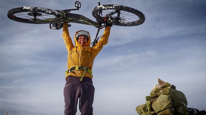 Endura cyclists hold bike above the head