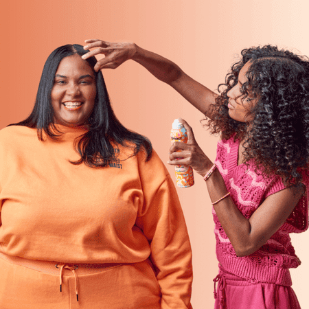 Two people applying dry shampoo