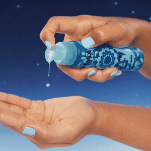 Person pumping water sign hydrating hair oil into hand
