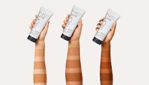 three arms of different skin tones with different fake tan lines