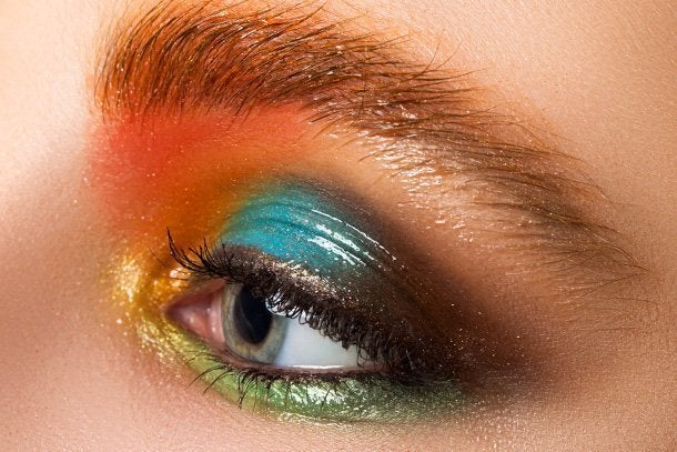  A extreme close up of a model wearing multicoloured glossy eyeshadow make up look as she’s prepping for the party season.