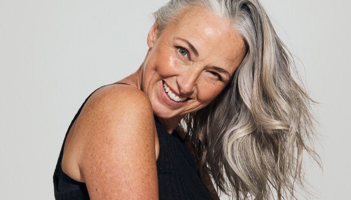 mature model with grey hair smiling at the camera