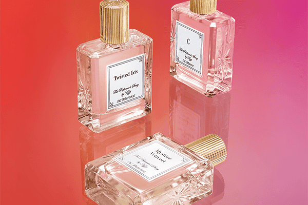 three bottles of the perfumers story shot in a studio on a pink background
