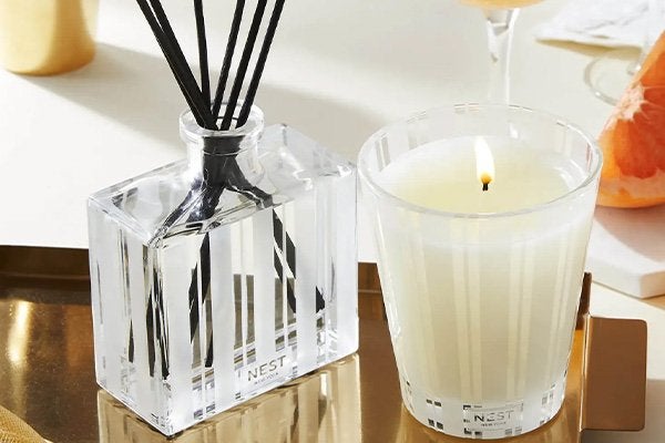 home fragrance diffuser and candle on table top 