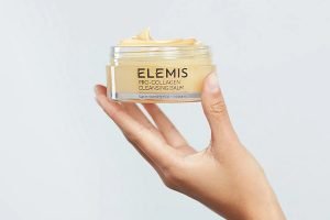 elemis pro collagen balm being held by a models hands
