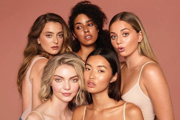 A group of models posing with coffee inspired make up looks 