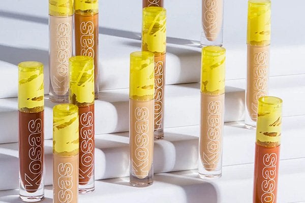 Studio image of the Kosas Revealer Super Creamy and Brightening Concealer in a range of shades, sitting on various platforms on white shelving
