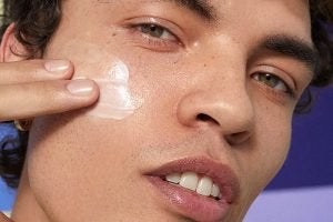 male model with a streak of moisturiser on his cheek