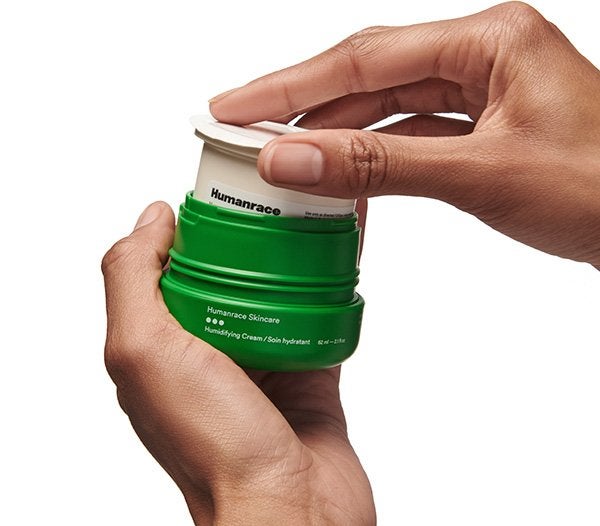 A zoomed in shot of a model's hand popping out and refilling his Humanrace's Humidifying Cream skin care,on a white background.